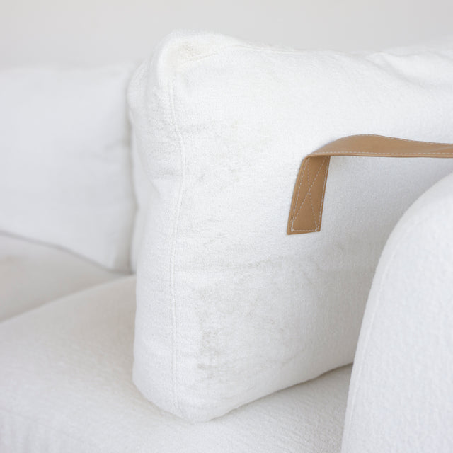 coussin de dossier blanc avec sangle en cuir beige sur canape moderne.