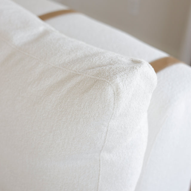 coussin de dossier blanc avec sangle en cuir clair sur canape elegant.