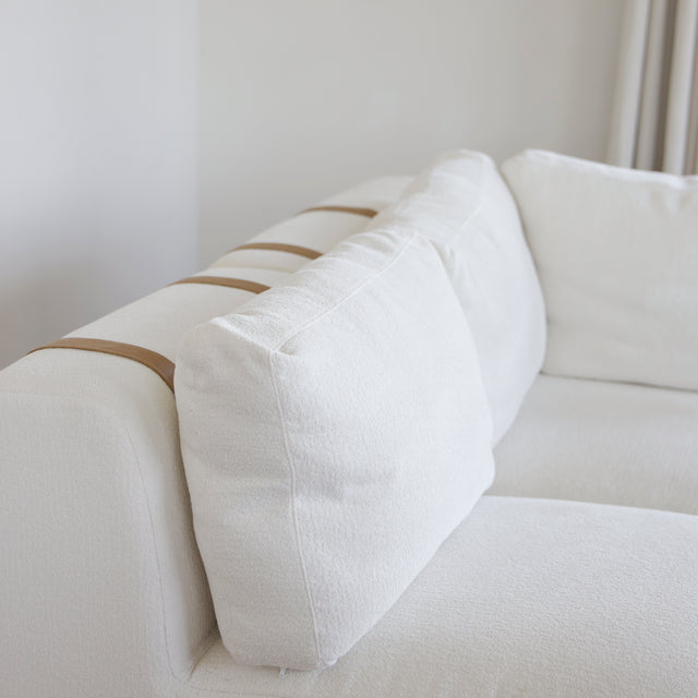 canape blanc moderne avec coussins attaches par sangles en cuir beige.