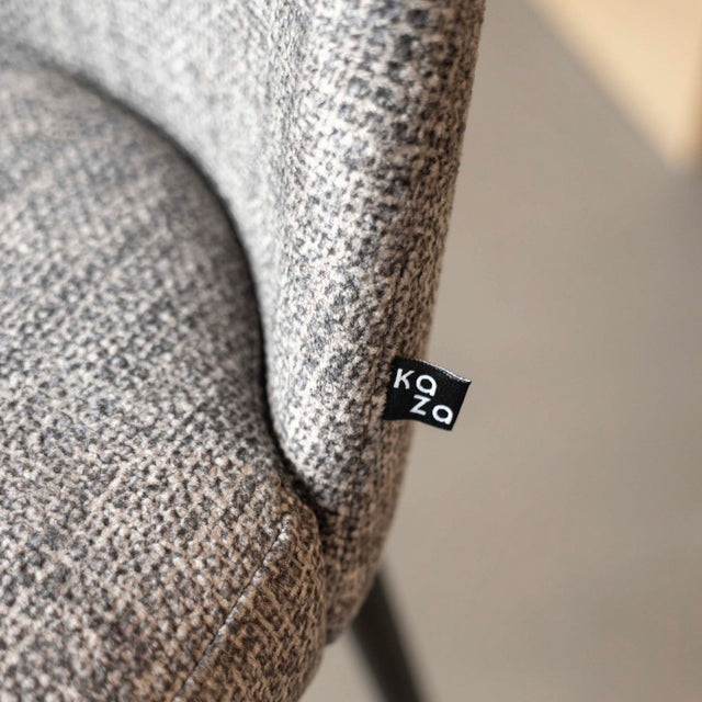 Tabouret de bar design avec assise en tissu brun/gris et pieds en metal noir, ideal pour cuisine moderne.