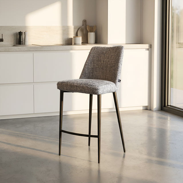 Tabouret de bar design avec assise en tissu brun/gris et pieds en metal noir, ideal pour cuisine moderne.