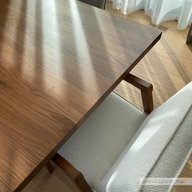 Table en bois avec chaise grise moderne baignee de lumiere naturelle.