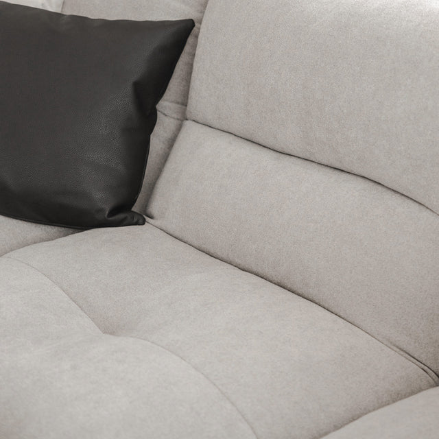 Gros plan sur canape gris clair moderne avec coussin decoratif noir.