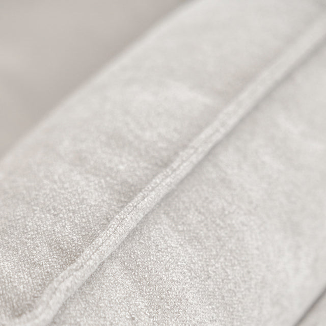 Gros plan sur la texture du tissu gris clair d’un canapé moderne.