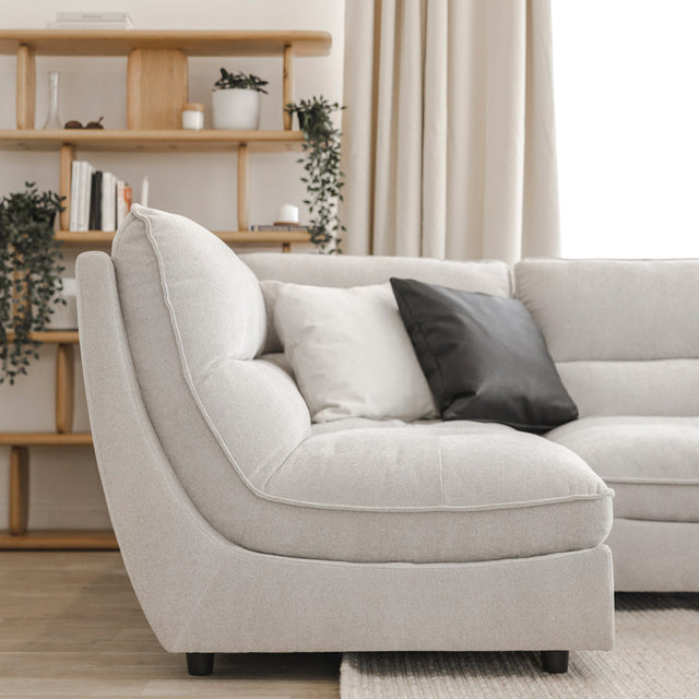 Angle du canape sectionnel gris clair moderne avec coussins noirs et blancs.