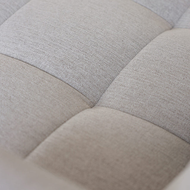 Gros plan sur tissu beige clair matelasse d un canape moderne en maille texturee.