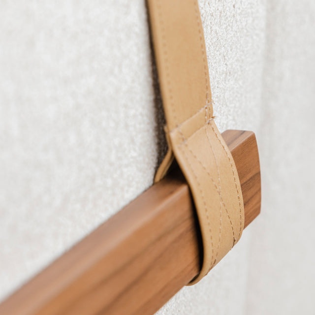 detail d une sangle en cuir beige fixee sur baguette en bois de noyer du canape.