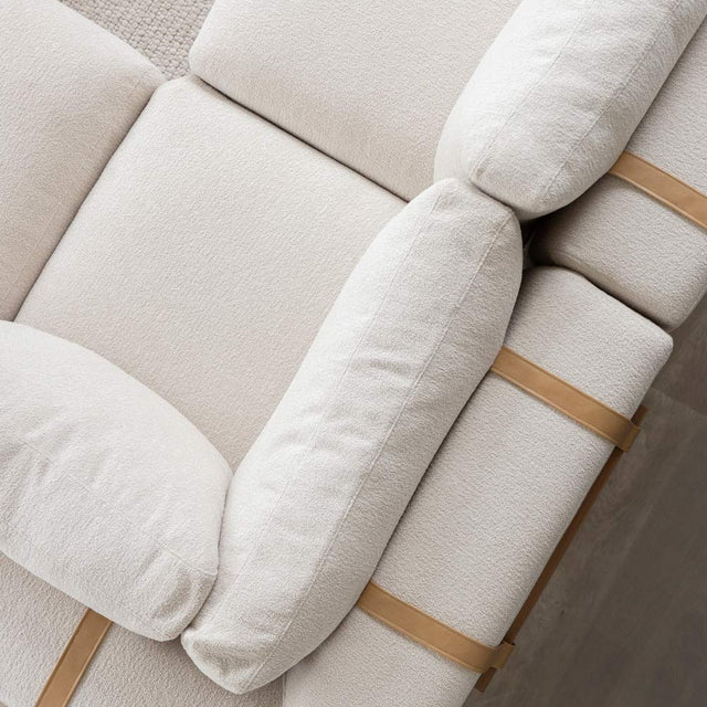 vue du dessus d un canape beige clair avec coussins et sangles en cuir beige.