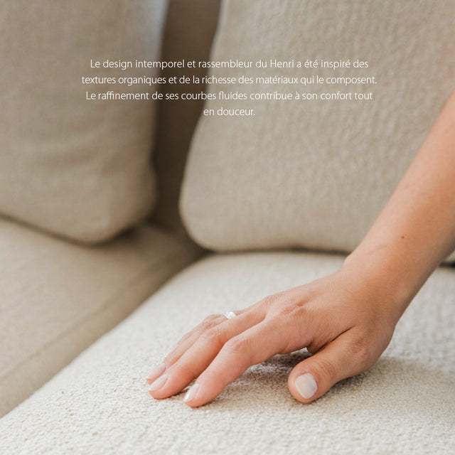 main reposee sur tissu boucle beige clair du canape confortable et elegant.