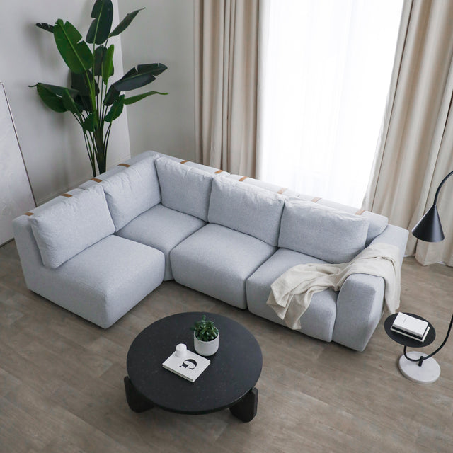 canape d angle gris clair avec plaid beige dans salon moderne et lumineux.