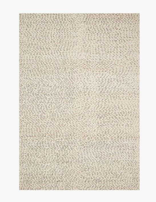 tapis beige clair à texture bouclée et motif subtil ton sur ton.