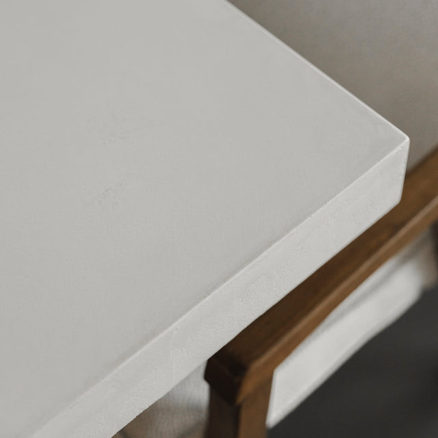 coin de table en beton blanc avec chaise beige et structure en bois.