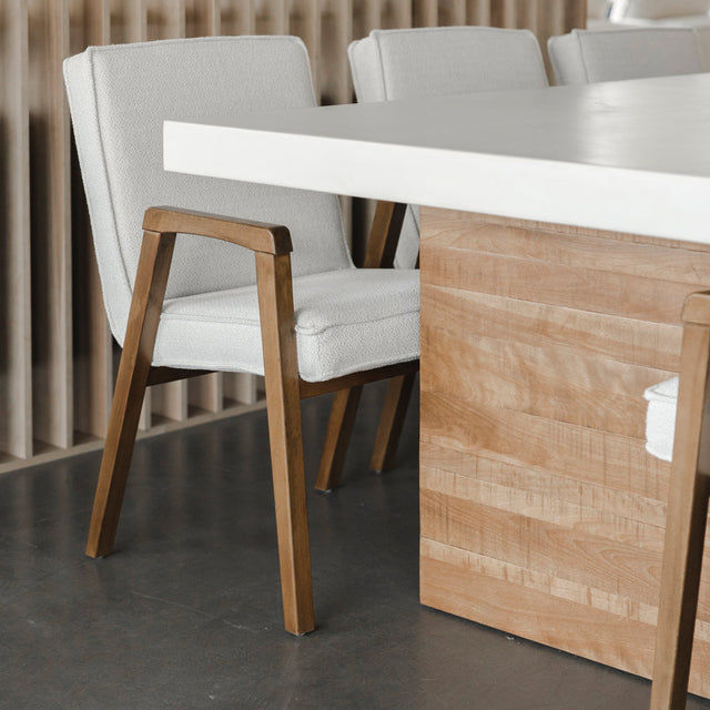 table en beton clair avec pied en bois naturel et chaises beige elegantes.