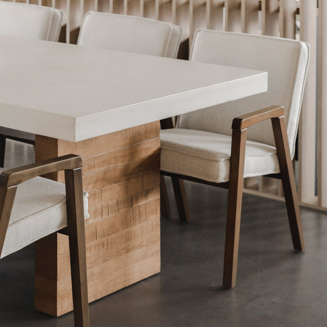 table en beton clair avec pied en bois massif et chaises beige modernes.