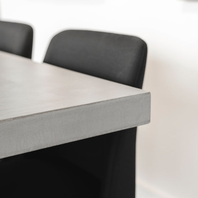 bord de table en beton gris avec chaise noire au design contemporain.