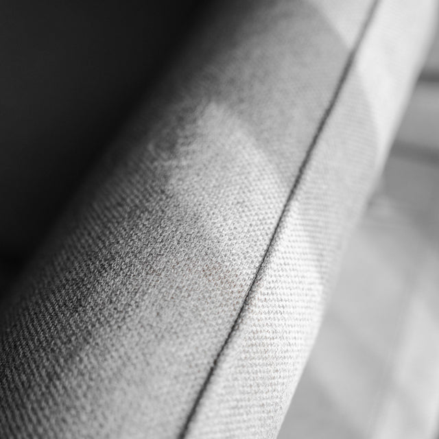 gros plan sur la texture du tissu clair du canape avec couture detaillee.