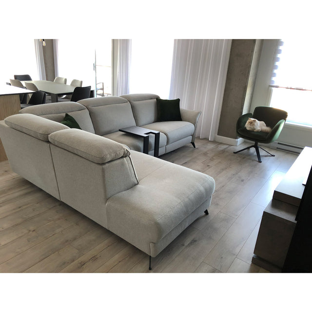 canape d angle clair avec tetieres reglables dans un salon moderne lumineux, fauteuil vert et parquet bois clair.