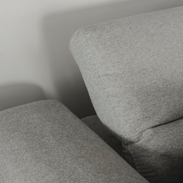gros plan sur l appui tete reglable du canape en tissu gris clair.
