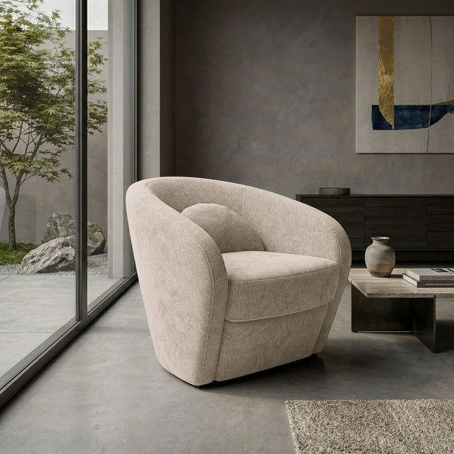 Fauteuil arrondi en tissu beige avec coussin, dans un salon moderne lumineux.