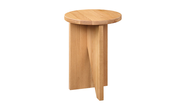 Table d'appoint en bois clair au design minimaliste pose sur tapis texture dans un interieur moderne.