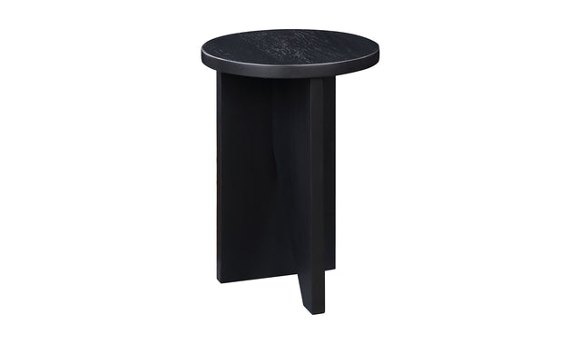Table d'appoint en bois noir au design minimaliste pose sur tapis texture dans un interieur moderne.