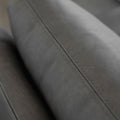 detail de la couture fine sur le dossier du fauteuil en cuir gris.
