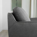 zoom sur le dossier capitonne du fauteuil en cuir gris avec couture detaillee.
