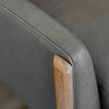 detail de l accoudoir en cuir gris et finition en bois clair du fauteuil.
