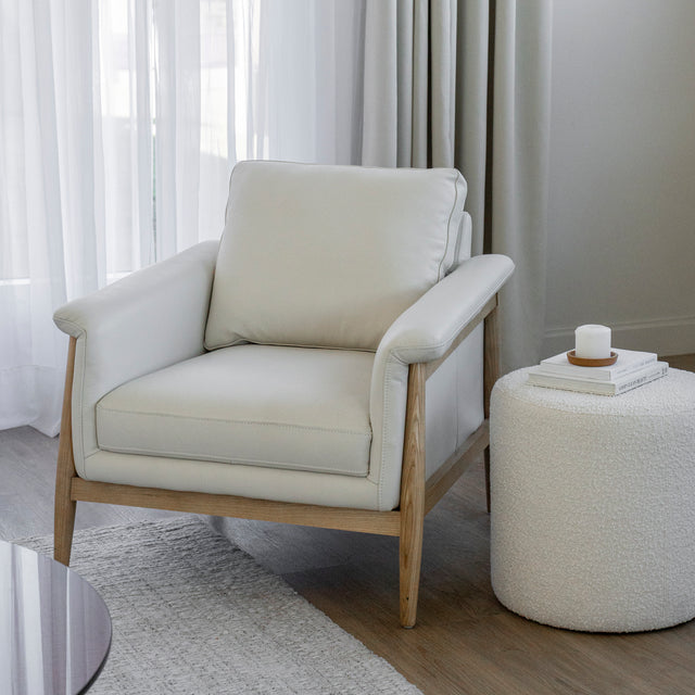 fauteuil en cuir crème avec structure en bois clair dans un salon lumineux.