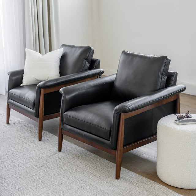 Fauteuil en cuir noir avec structure en bois dans un salon moderne.