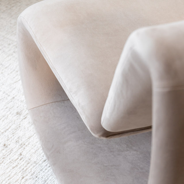 Détail ottoman beige en tissu doux, surface lisse et finition arrondie pour salon élégant.