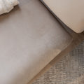 Détail ottoman beige en tissu doux, surface lisse et finition arrondie pour salon élégant.
