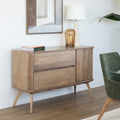 Buffet en bois clair style scandinave avec portes rainurées, pieds inclinés et déco minimaliste dans un salon moderne.