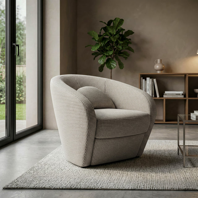 Fauteuil arrondi en tissu beige motif pied-de-poule, dans un salon moderne avec lumière naturelle.