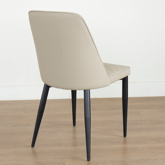 Chaise moderne taupe avec pieds noirs coniques, design elegant pour salle a manger.