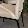 chaise moderne en tissu beige avec pattes noires.