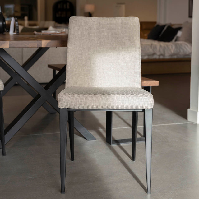 chaise moderne en tissu beige avec pattes noires.