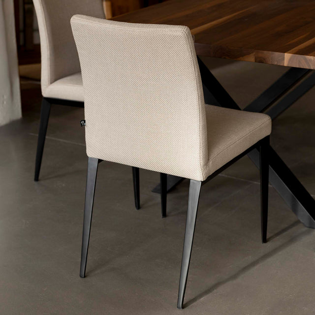 chaise moderne en tissu beige avec pattes noires.