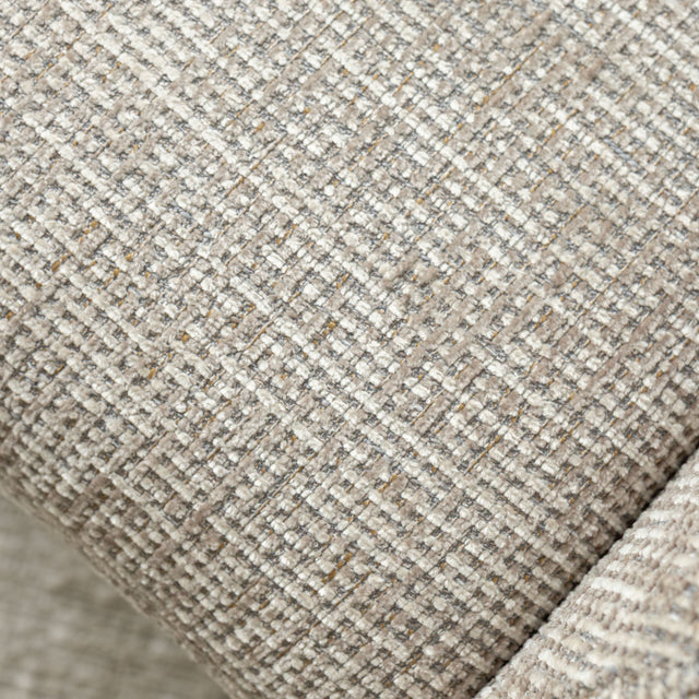 Fauteuil en tissu beige avec dossier inclinable et base pivotante, dans un salon lumineux et épuré.