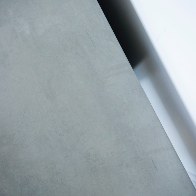 Image rapprochée d'un Meuble TV moderne en bois de noyer et beton gris avec tiroirs et etageres ouvertes.