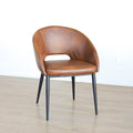 Chaise moderne en cuir cognac avec dossier incurvé et pieds noirs élegants.