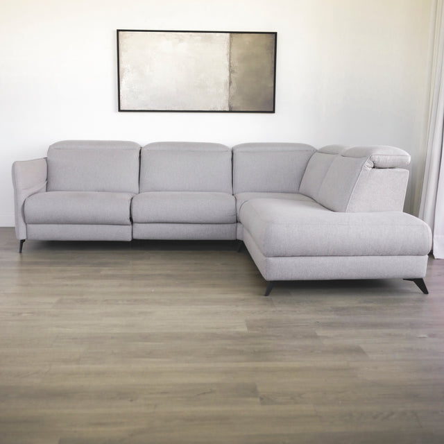 canape d angle gris clair moderne avec accoudoirs et pieds noirs dans salon minimaliste.