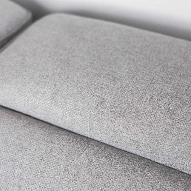 gros plan sur le tissu gris clair texturee du coussin de siege de canape moderne.
