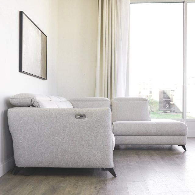 canape d angle gris clair moderne avec tetiere reglable et accoudoir lateral.
