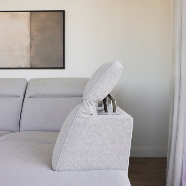 tetiere reglable en metal et tissu gris clair sur canape d angle moderne.
