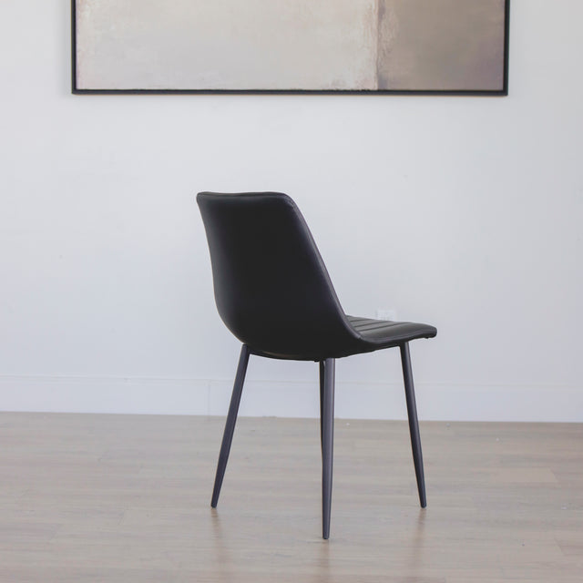 chaise moderne en simili cuir noir avec pieds en metal fins.