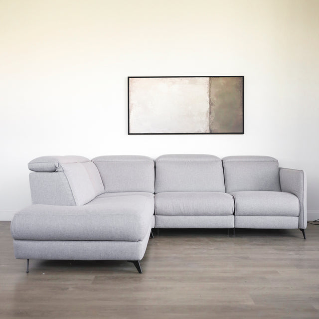 canape d angle gris clair moderne avec accoudoirs et pieds noirs dans salon minimaliste.