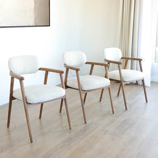 Lot de trois chaises style scandinave avec structure en bois et assise beige rembourrée avec cercles indiquant les défauts.