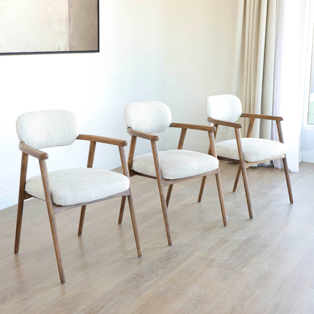 Lot de trois chaises style scandinave avec structure en bois et assise beige rembourree.