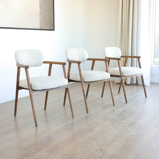 Lot de trois chaises style scandinave avec structure en bois et assise beige rembourree.